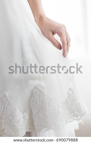 Beautifully folded hands of the bride on the dress. Sweet and romance style, Focus on hand, Selective focus.