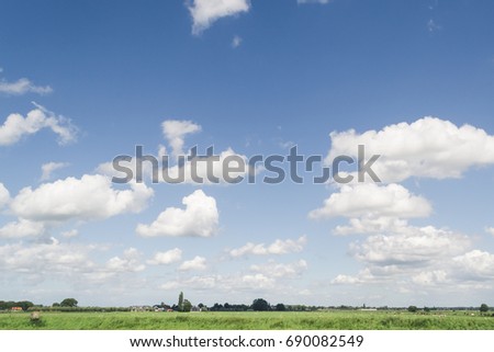 Bright countryside photo with fluffy clouds on a blue sky