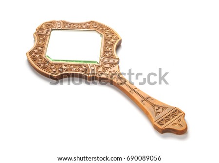 Ancient wooden hand mirror lies on a white background