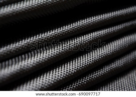 Black carbon fiber composite raw material close up background