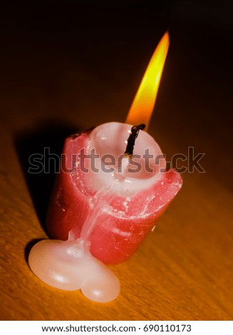 A close-up photograph of a small burning candle. This photo was taken in Brisbane, Australia. 