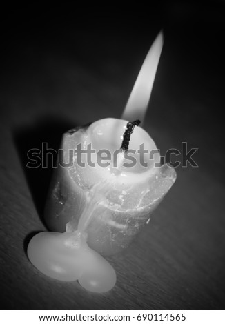 An artistically manipulated, greyscale photograph of a burning candle. This photo was taken in Brisbane, Australia. 