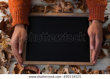 Close-up of hand holding slate o wooden table