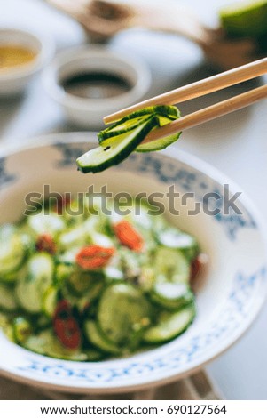 Cucumber salad in Chinese chopsticks, Asian cuisine, spices