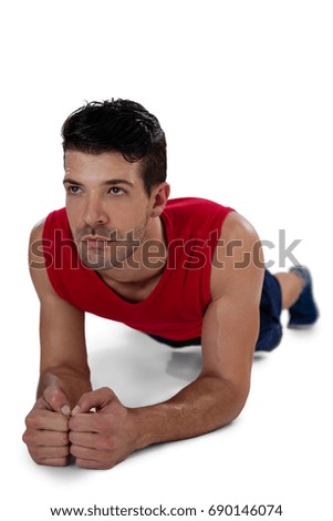 Determined sports player doing plank exercise against white background
