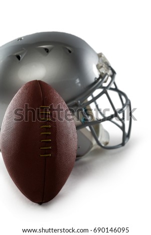 Close-up of football and sports helmet against white background