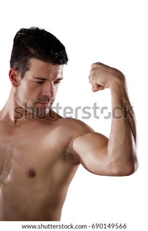 Shirtless American football player flexing muscles against white background