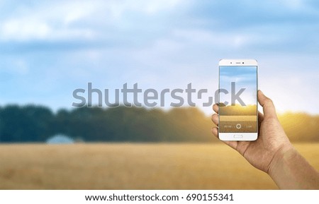 Tourist taking a picture of field using a smartphone, point of view shot