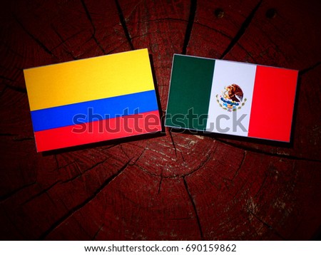 Colombian flag with Mexican flag on a tree stump isolated