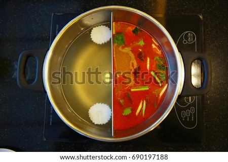 close up shabu pot in Chinese style , pork soup and tomyum spicy soup.Japan food hotpot two styles of shabu soup.2 in 1 soup in shabu pot .
