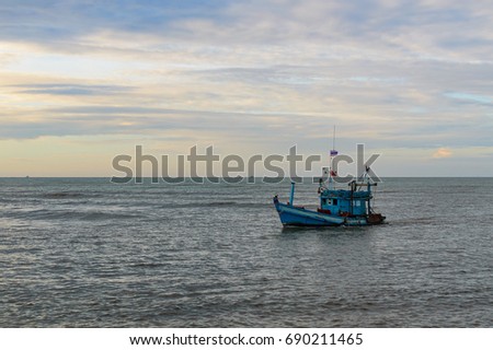 A lonely wooden fishing boat returns to the village after night catching at dawn in thailnd province Khlong Yai