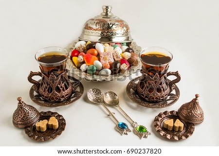 Traditional Turkish tea in vintage glasses on white with Turkish Delights,candy