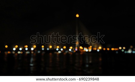 Dark night river and blur bridge view with the colorful night light, bridge in bangkok, thailand