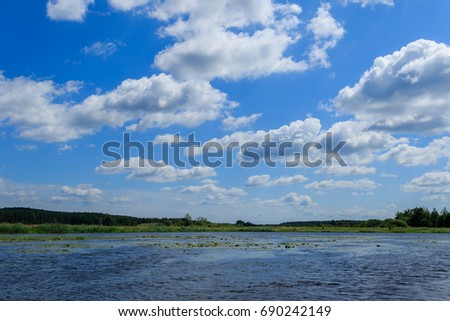 Landscape of wild river under the blue sky with white clouds