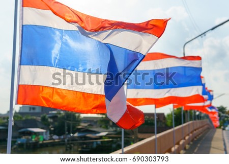 close up. thai flags on the pole blown by wind at the bridge in sunny day