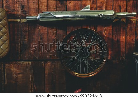 Motorcycle old iron tube and wheel hanging on wooden wall in the garage with blank copy space