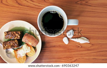Serve morning coffee with European and Asian snacks on wooden.