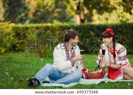 The couple in love on picnic drinking wine