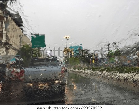 Blur picture wet rain drop on front mirror car on the road in city