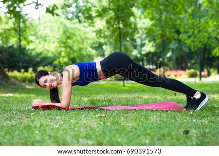 young fitness woman exercise in a park in summer