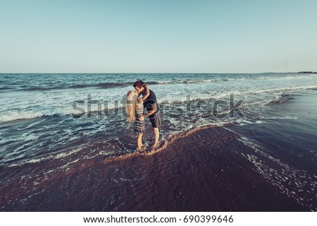 The young couple in love walking on the beach