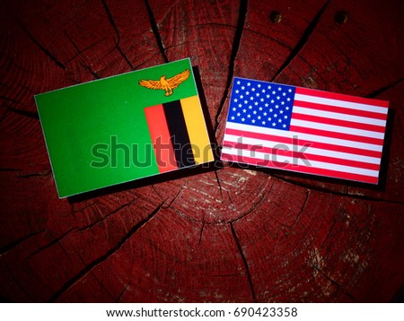 Zambian flag with USA flag on a tree stump isolated