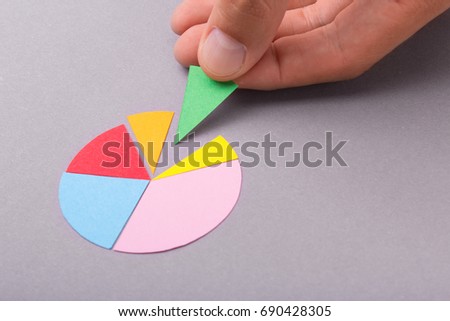 Round radial diagram with colored parts in the hands of a man on a gray background. Copy space for text