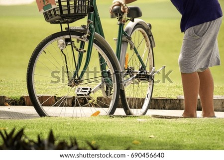 Boy prepare to ride the bicycle in the garden