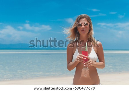 Girl in bikini drink juice through a straw. Summer time