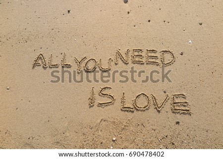 Handwriting  words "ALL YOU NEED IS LOVE" on sand of beach.