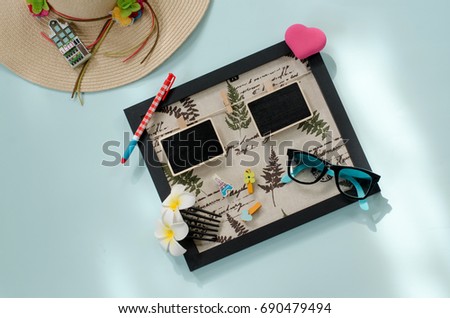 holiday and travel concept. Woman's hat and picture frame with copy space on blue background