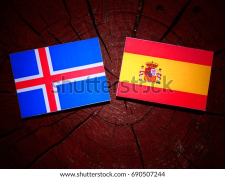 Icelandic flag with Spanish flag on a tree stump isolated