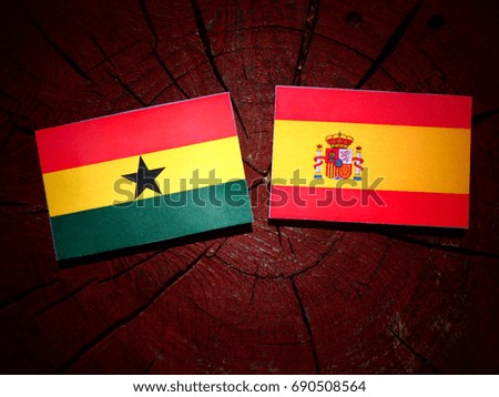 Ghanaian flag with Spanish flag on a tree stump isolated