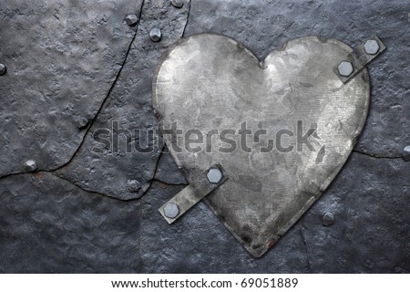 Photo of a galvanized metal heart bolted to old hammered metal plates with rivets.