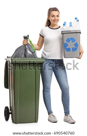 Full length portrait of a young girl with a recycling bin and a garbage bag next to a trash can isolated on white background