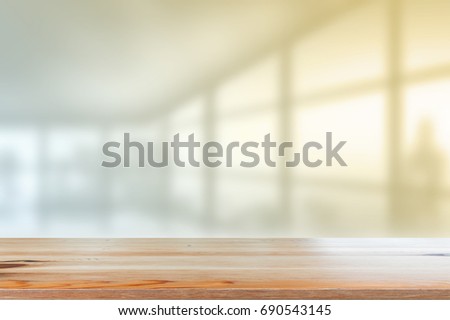 Wooden desk with Blurred of interior office room with city building background.
