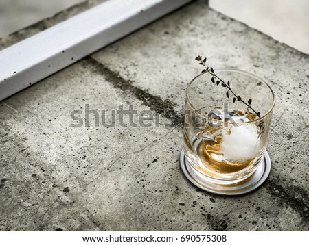 Empty glass of tea have circle cube ice on the concrete table, blurred background