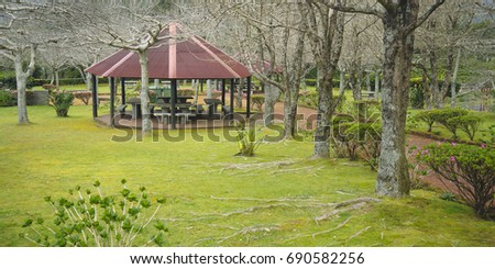 recreational area with a nice cabin, tables and benches made of stone in the forest