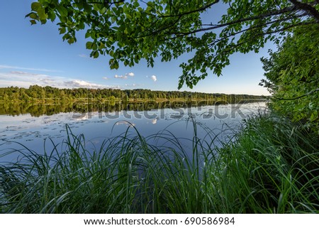 reflection of clouds in the lake with forest  and trees in background and horizon line