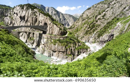 Andermatt, Switzerland: Gorge Schoellenen where flows the river Reuss and the devil bridge called "Teufelsbruecke" Royalty-Free Stock Photo #690635650