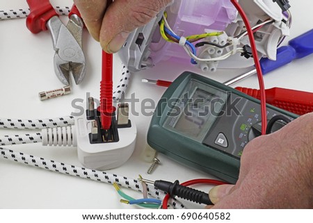  Continuity testing – An electrician testing for a fault on the live cable with a multimeter  Royalty-Free Stock Photo #690640582