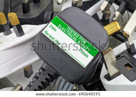 plan view of plugs – Blurred background of  three pin plugs with top of plug  with test sticker Royalty-Free Stock Photo #690640591