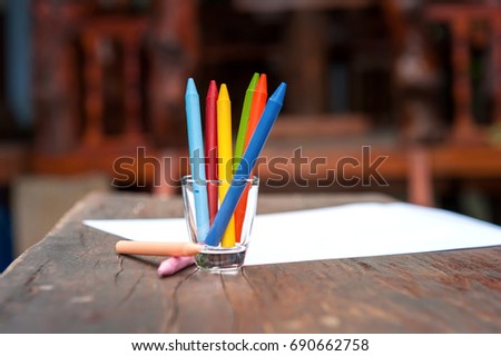 Colorful  Crayons on a wooden table out side home. 