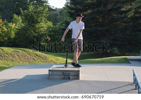 Teenager standing on top of jump at skate park.