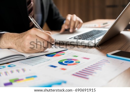business person making a note on the desk.