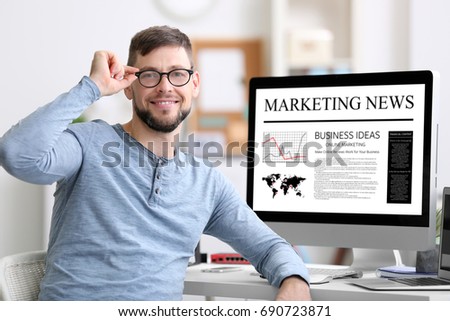 Man working in office. Marketing news on computer screen