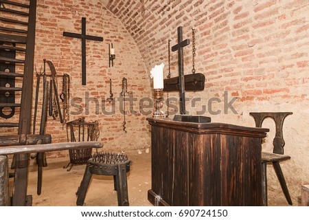 Inquisition torture chamber. Old medieval torture chamber with many pain tools. Medieval torture chamber with torture instruments. The concept of cruelty, pain and punishment in medieval Europe. Royalty-Free Stock Photo #690724150