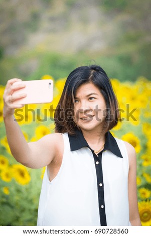 Young women making selfie in Sunflower field