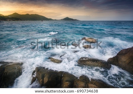 A beautiful photogenic of a seascape waves crash the rocks taken along the ocean Thailand Gulf on the back of green mountains