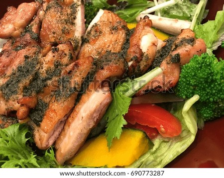 Vegetable salad topped with grilled chicken